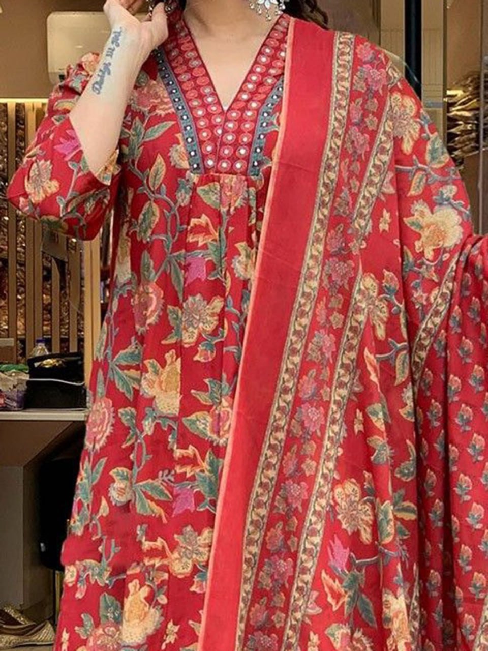 Red floral patterned dress with a matching dupatta, held by a person.
